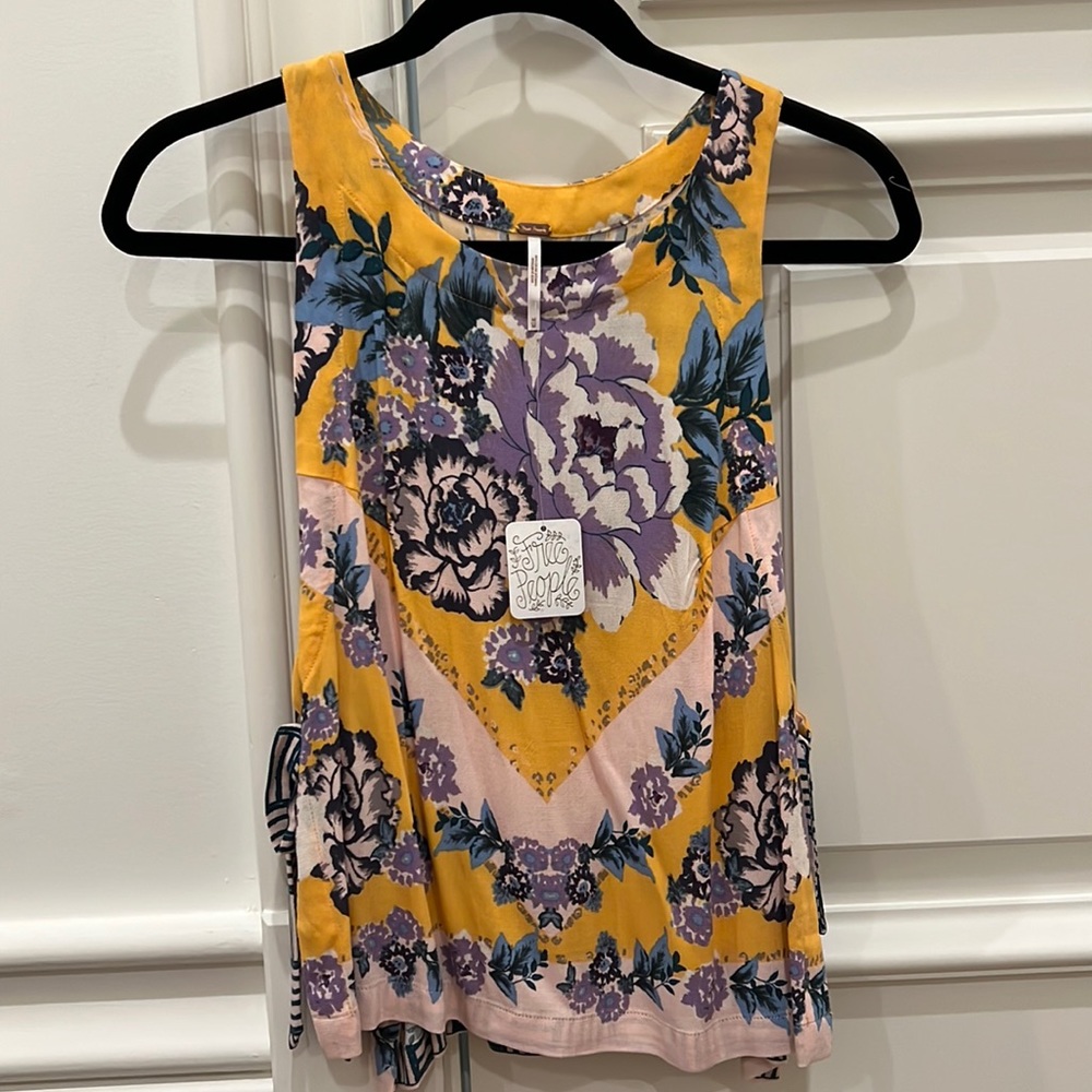 Free people Top size M. New with tags. Purple and yellow top with ties.